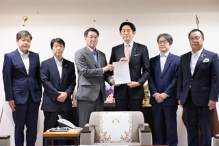 　自民党の小林政調会長（右から３人目）に要望書を手渡す新潟市の中原八一市長＝１６日午後、東京・永田町の党本部
