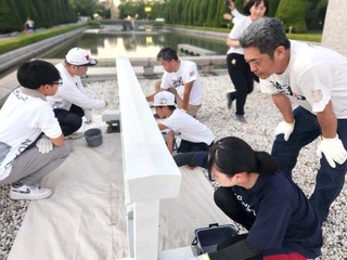 　広島市の平和記念公園で柵を白く塗るボランティア＝２０２５年７月（塗魂ペインターズ事務局提供）