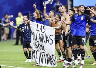 　イングランド戦後に、フォークランド諸島に関する旗を掲げて喜ぶアルゼンチンの選手たち＝アトランタ（ロイター＝共同）