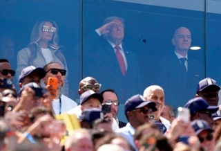 　決勝のスペイン-アルゼンチン戦の観戦に訪れ、国歌斉唱時に敬礼するトランプ米大統領（中央）。右はＦＩＦＡのインファンティノ会長＝ニューヨーク（共同）