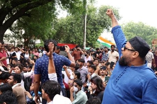 　拳を突き上げインドのプラダン教育相辞任を訴えるデモ参加者＝２０日、ニューデリー（共同）