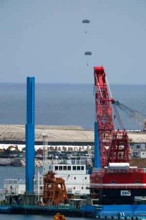 　米海兵隊が沖縄県名護市辺野古沖で実施したパラシュート降下訓練。手前は米軍普天間飛行場の移設に向けた工事が進む大浦湾＝２１日午後