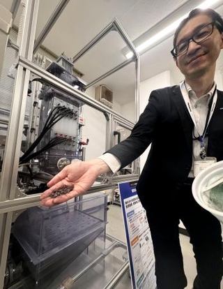 　パナソニック環境エンジニアリングの廃液から金属を回収する装置の実証機と、回収した銅粉末＝２１日午後、大阪府吹田市