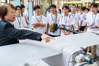 　雲林科技大の研究者（左）からドローンの解説を受ける高校生ら＝２１日、台湾中西部・雲林県（共同）