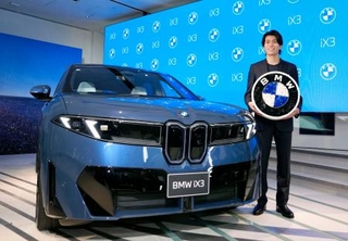 　ＢＭＷの新型ＥＶ「ＢＭＷ　ｉＸ３」と写真に納まるサッカー日本代表の中村敬斗選手＝２２日午後、東京都港区