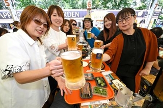 　札幌市中心部の大通公園で始まった「さっぽろ大通ビアガーデン」でビールを楽しむ人たち＝２３日午後