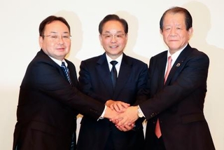 　記者会見を終え、ポーズをとるいよぎんＨＤの三好賢治社長（中央）ら＝２４日午後、松山市