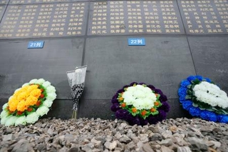 　「唐山地震遺跡記念公園」で犠牲者の名前が刻まれた石壁の前に置かれた花＝１０日、中国河北省唐山市（共同）