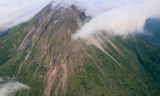 　地震で一部が崩落した雲仙・普賢岳の溶岩ドーム「平成新山」＝２９日午前６時１９分、長崎県・島原半島（長崎県提供）