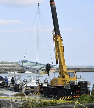 　沖縄県名護市の辺野古漁港で引き揚げられる、転覆した船「平和丸」＝３月１６日