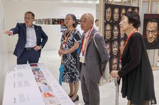 　寄港した世界一周クルーズ船内で洋上特別展を見学する（右から）田中稔子さんと広島県被団協の佐久間邦彦理事長＝２８日午前、広島市