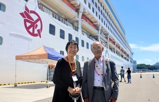 　寄港した世界一周クルーズ船の前に立つ田中稔子さん（左）と広島県被団協の佐久間邦彦理事長＝２８日午後、広島市