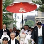 　京都・祇園祭の無事を祈願する「お千度の儀」で、八坂神社を参拝する稚児の長谷航太郎さん（中央）ら＝１日午前、京都市東山区
