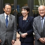 　　２０２６年度予算案が衆院を通過後、自民党の麻生副総裁（左）と笑顔で言葉を交わす高市首相。右は鈴木幹事長＝３月１３日、国会