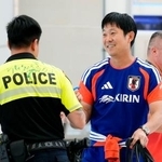 　ヒューストンの空港に到着し、警察官の背中にサインした森保監督（右）＝１日（共同）