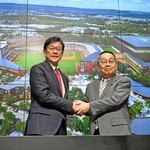 　記者会見で握手するプロ野球日本ハムの栗山英樹ＣＢＯ（左）と北海道恵庭市の原田裕市長＝２日午前、エスコンフィールド北海道