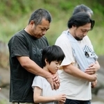 　２０２０年７月の豪雨から６年となり、氾濫で多くの被害をもたらした球磨川に向かい黙とうする人たち＝４日午前、熊本県八代市