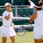　女子ダブルス３回戦でポイントを奪い、ガッツポーズする青山修子。右は梁恩碩＝ウィンブルドン（共同）