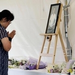 　安倍元首相銃撃事件から４年、現場付近の献花台で手を合わせる人＝８日午前、奈良市