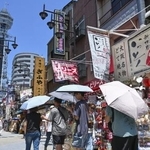 　日傘を差して大阪・新世界を歩く人たち＝９日午後