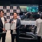 　協業を発表した三菱自動車の加藤隆雄会長兼ＣＥＯ（右）とハイランダーズの増岡宏哉ＣＥＯ。車の手前は人型ロボット＝９日午後、東京都港区