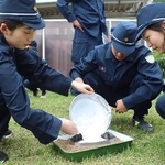 　鑑識の授業で、足跡に石こうを流し入れる記者（左）。右は松葉花帆巡査＝６月、長野県警察学校（代表撮影）
