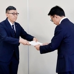 　宮城県名取市役所で、第三者委員会の鎌田健司委員長（右）から中学３年の男性の飛び降りに関する報告書を受けとる教育長＝１０日午前