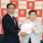 　文化庁の松坂浩史審議官（左）に署名を提出する「関西・歌舞伎を愛する会」の堀井良殷代表世話人＝１０日午後、京都市上京区