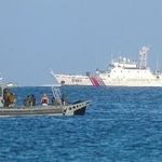 南シナ海・南沙諸島のパグアサ島沖をパトロールするフィリピン海兵隊のボート（手前）。中国海警局の艦船が見える＝５月３日（ゲッティ＝共同）