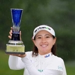 　通算１９アンダーで優勝し、トロフィーを手に笑顔の永井花奈＝真駒内ＣＣ