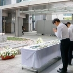 　小学女児らが死亡した集団食中毒から３０年となり、堺市役所前の追悼式典で献花し、祈りをささげる参列者＝１２日午後
