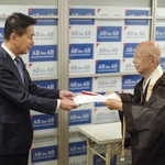 　前原誠司衆院議員（左）にルート見直しを求める署名を提出する京都仏教会の宮城泰年常務理事＝１３日午前、京都市