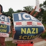 　移民・税関捜査局（ＩＣＥ）に抗議し、「ＩＣＥはナチ、クズ」とのプラカードを掲げる人たち＝１４日、メーン州ビデフォード（ロイター＝共同）