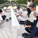 　広島市の平和記念公園で柵を白く塗るボランティア＝２０２５年７月（塗魂ペインターズ事務局提供）