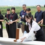 　硫黄島の天山慰霊碑で献花する弟子丸香里奈さん（手前）＝１８日午前、東京都小笠原村（代表撮影）