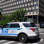 　放火事件があった移民・税関捜査局（ＩＣＥ）などが入る連邦庁舎そばに停車した警察車両＝２０日、米ニューヨーク（ロイター・共同）