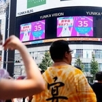 　熱中症警戒アラートが発表されていることを知らせる東京・新宿の大型ビジョン＝２２日午後