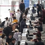 　昨年１１月、北京首都空港の日本便などを扱うカウンターで搭乗手続きをする人たち（共同）
