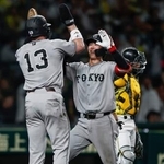 　１０回、決勝２ランを放ちキャベッジ（１３）に迎えられる巨人・小浜＝甲子園