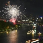 　奉納花火が夜空を彩り、大川を船が行き交う天神祭の「船渡御」＝２５日夜、大阪市