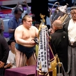 　大相撲名古屋場所で優勝し、日本相撲協会の八角理事長（右）から賜杯を受け取る安青錦＝２６日、名古屋市のＩＧアリーナ