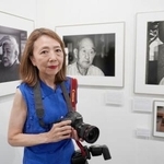 　樺太引き揚げ者を写した写真展で、自身の作品の前に立つ広瀬明代さん＝２７日午後、東京都新宿区