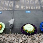 　「唐山地震遺跡記念公園」で犠牲者の名前が刻まれた石壁の前に置かれた花＝１０日、中国河北省唐山市（共同）
