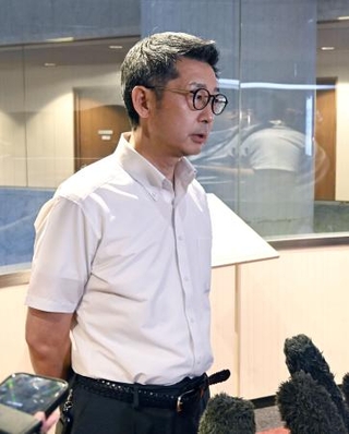 　７月３０日、記者団の取材に応じる自民党福岡県議団の松尾統章会長＝福岡市