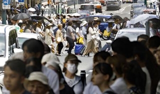 　気温４０度に迫る猛暑日となった京都市内を歩く人たち＝７月２３日