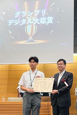 　「Ｕ１８　ＡＩチャンピオンシップ」で優勝した佼成学園高の星晴登さん（左）に大臣奨励賞を贈る松本デジタル相＝７日午後、東京都千代田区