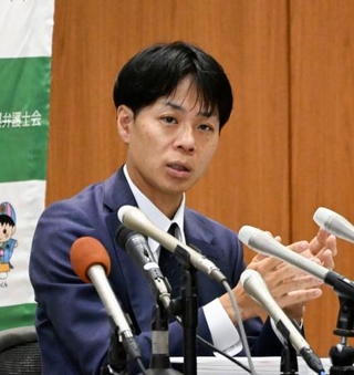 　再審請求の申し立て後、記者会見する弁護団の出口聡一郎弁護士＝７日午後、佐賀市