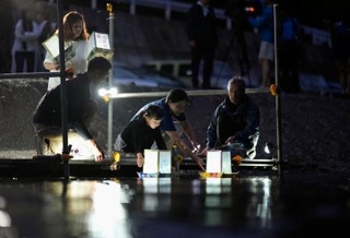 　日航ジャンボ機墜落事故から４１年となるのを前に「御巣鷹の尾根」の麓を流れる神流川に灯籠を流す人たち＝１１日夕、群馬県上野村