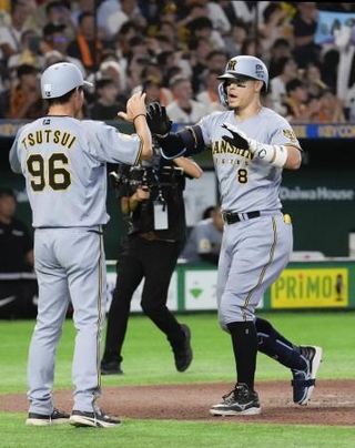　７回、通算１５０号本塁打を放ち、コーチに迎えられる阪神・佐藤＝東京ドーム