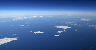 　北海道・根室半島の納沙布岬（左下）沖に広がる北方領土。歯舞群島（中央）、色丹島（右上）、国後島（左奥）。はるか右奥にうっすらと択捉島が見える＝２０１９年１月
